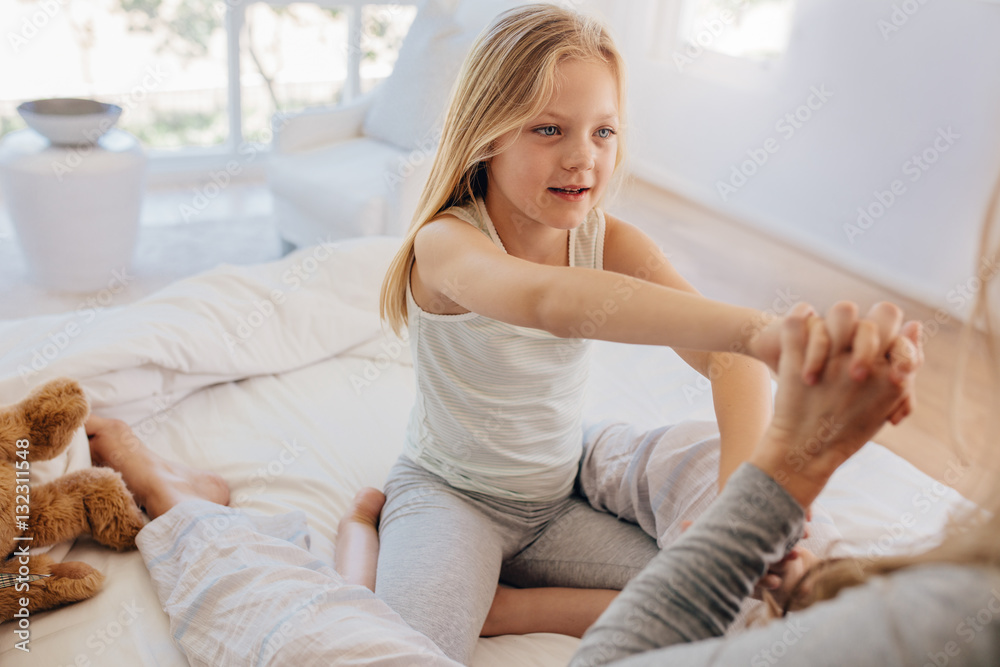 Beautiful little girl with her mother on bed Beautiful little girl with her mother on bed