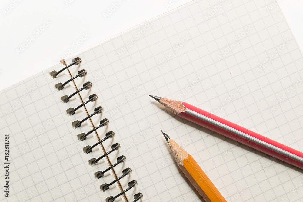 Pencils on the pages of an open notebook for records Pencils on the pages of an open notebook for records