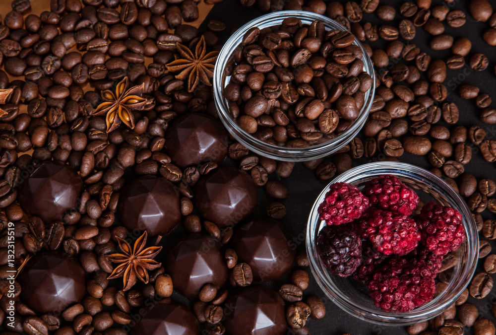 Fototapeta premium Chocolate sweets, coffee beans, dry raspberries background