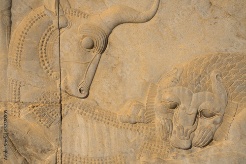 Carved relief of lion overcoming a bull, symbolising the advent of Spring and the Iranian New Year (Nowruz), Apadana Palace, Persepolis, Iran photo