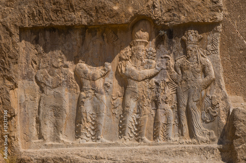 Carved relief of the Investiture of Narse, 294-302 AD, to the lower right of the Tomb of Darius the Great, Naqsh-e Rostam Necropolis, Iran photo