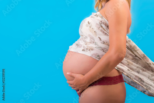 Pregnant Woman Belly. Pregnancy Concept. Isolated on a Blue Background © gg333