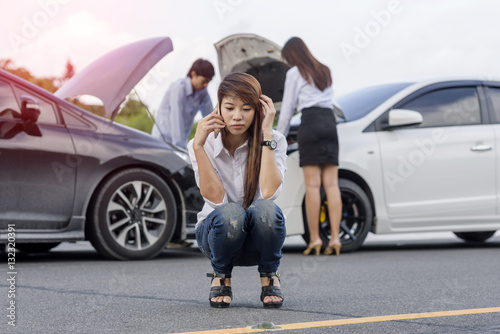 Woman calls for help and insurrance require by mobile phone after accident of car occurrence © ID_Anuphon