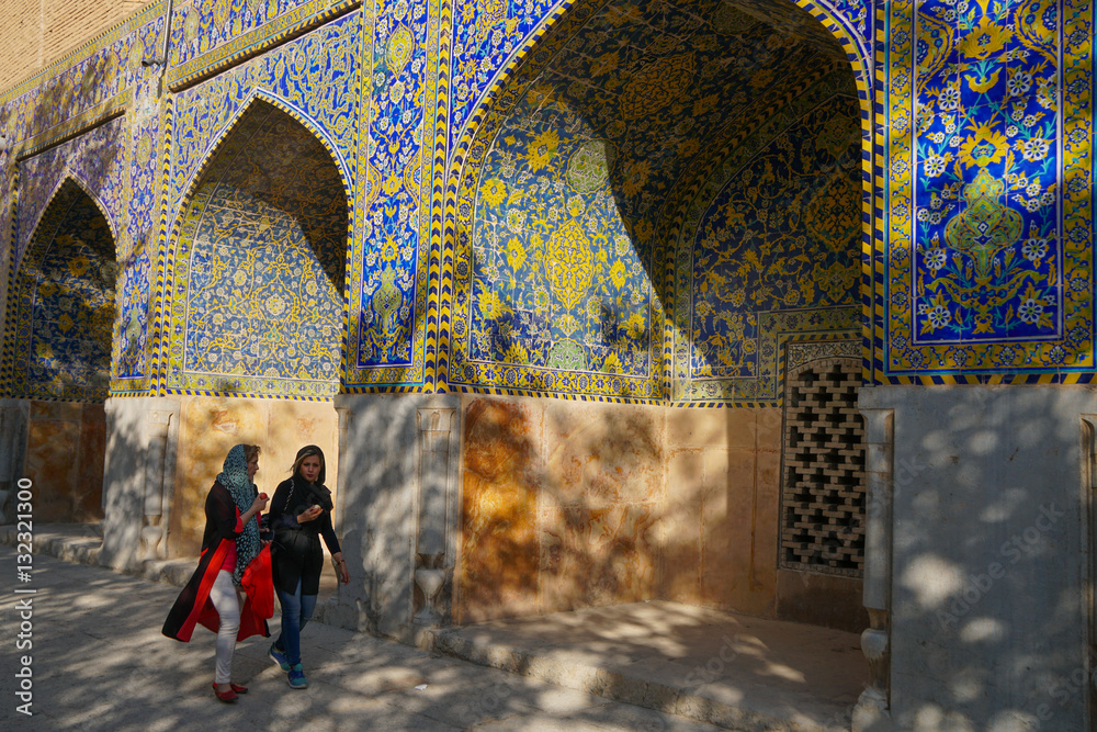 Two Iranian girls walking past courtyard walls, Imam Mosque, Isfahan ...