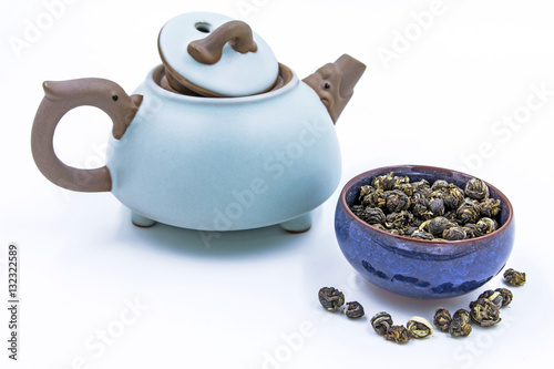 Chinese green tea Jasmine Pearl (Mo Li Long Zhu) in a blue ceramic bowl with small clay pot isolated on white.