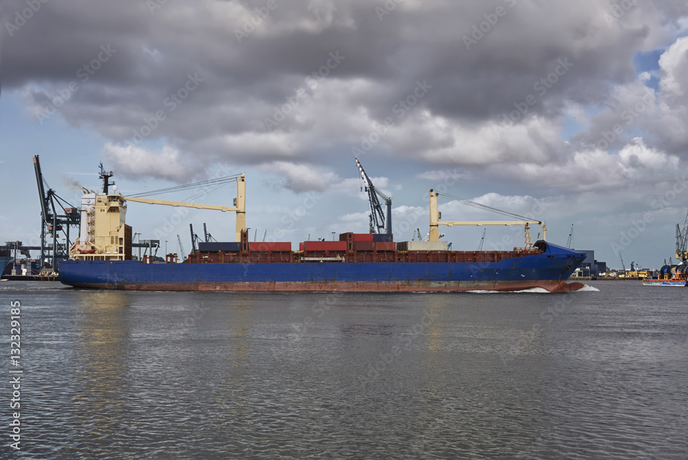 Panoramic image of a container ship passing cranes in Rotterdam