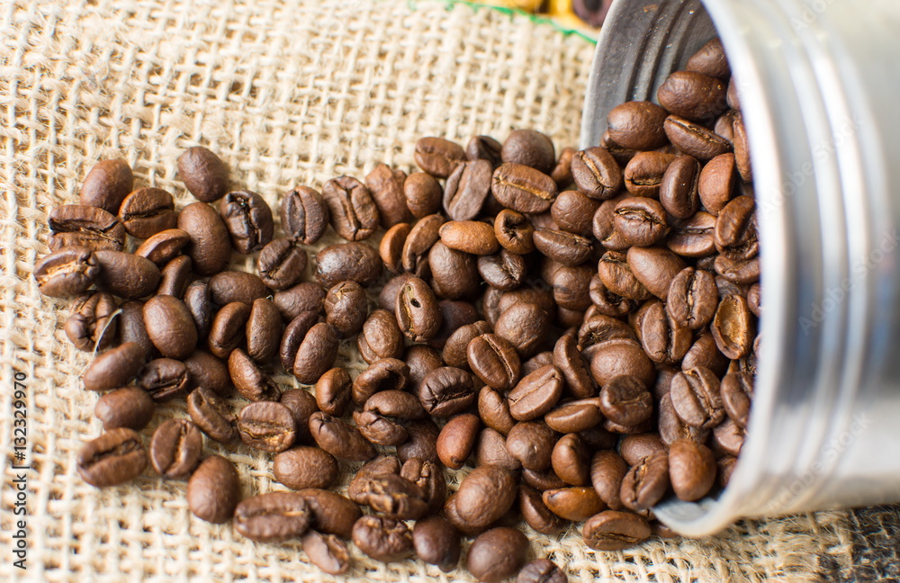 Roasted coffee beans falling of metal can Roasted coffee beans falling of metal can