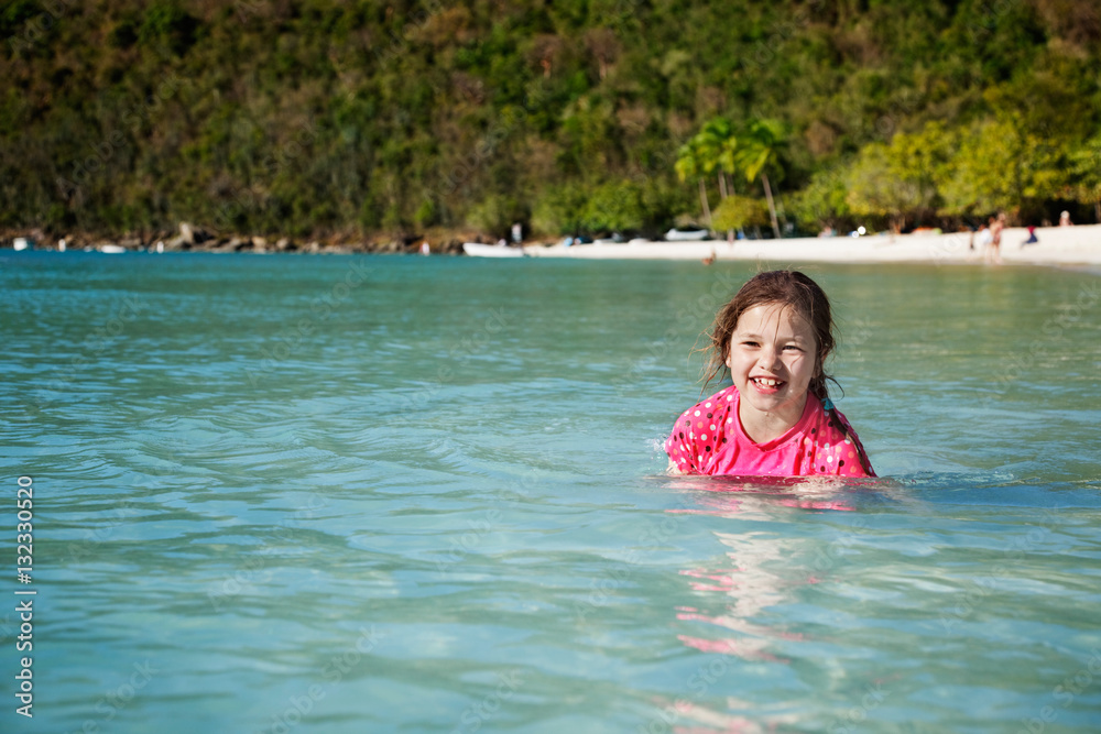 Young girl playing and laughing in the warm, clear water at Magens Bay, St. Thomas