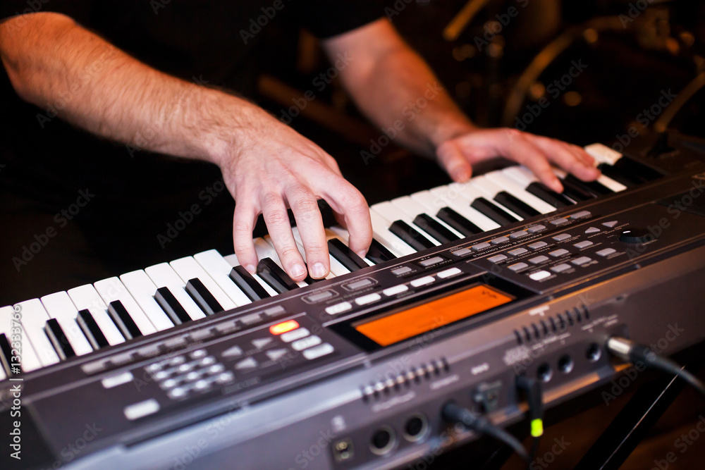 Close-up hands of musician who plays keyboards