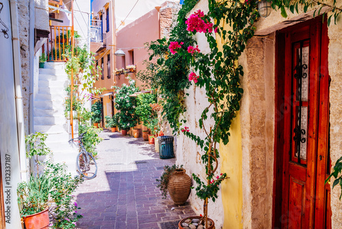 Fototapeta Naklejka Na Ścianę i Meble -  Colorful streets of old Chania town with blooming flowers and ancient stone, Crete, Greece.
