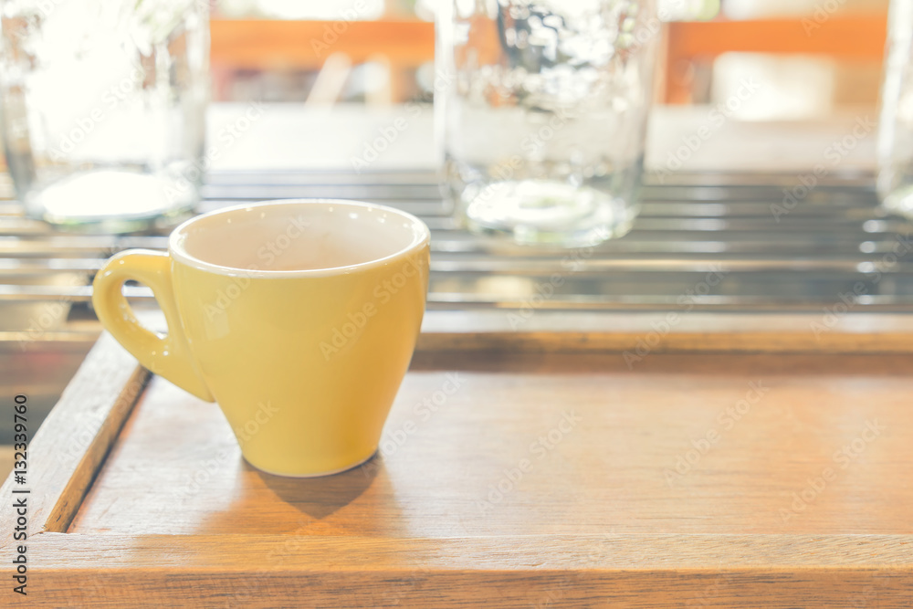 Hand holding yellow cup of coffee, Coffee espresso shot on woode Hand holding yellow cup of coffee, Coffee espresso shot on woode