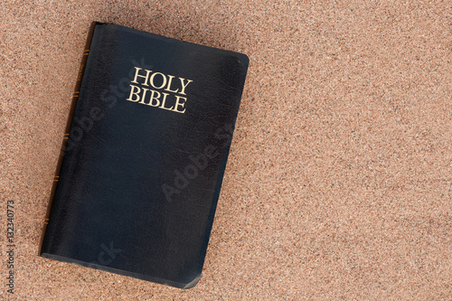 Holy Bible on sand. Top down view.