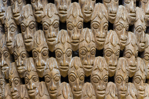 Pattern of many wood carved heads on chair at traditional Fon's palace in Bafut, Cameroon, Africa photo