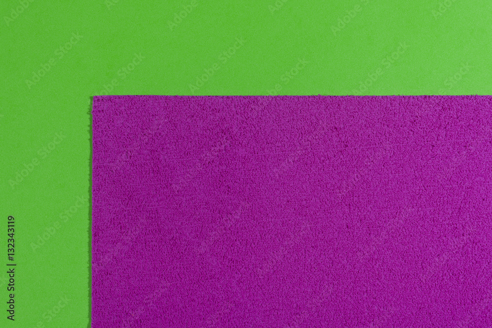 Fototapeta premium Eva foam ethylene vinyl acetate sponge plush pink surface on apple green smooth background