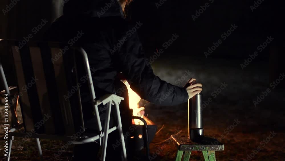 Woman pours hot tea from a thermos into a cup. Cold winter night. Shot with Dolly Slider. Woman pours hot tea from a thermos into a cup. Cold winter night. Shot with Dolly Slider.