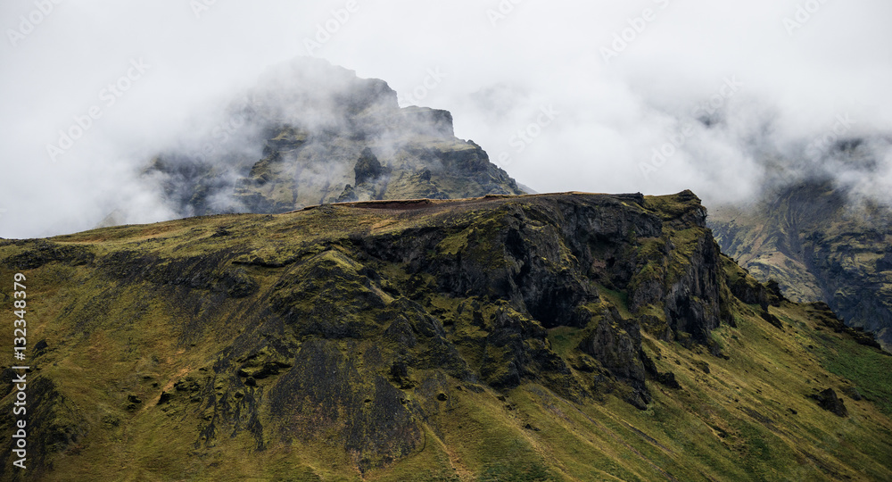 Fototapeta premium Volcanic rocks peeking out of the clouds on Eyjafjallajökull, Iceland