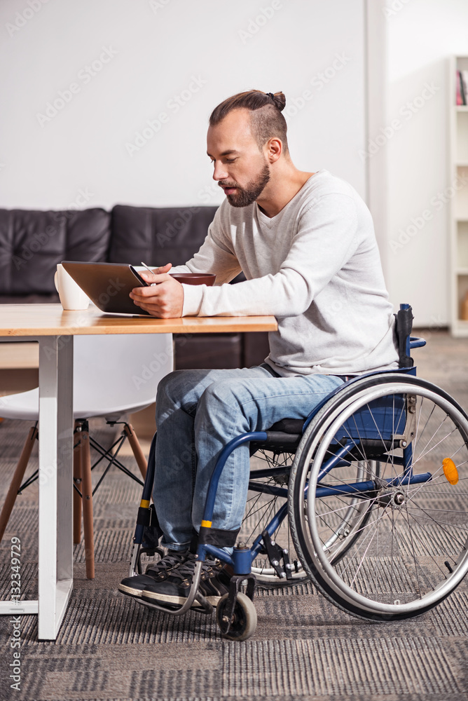 Focused handicapped man watching morning news Focused handicapped man watching morning news
