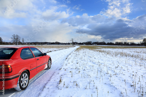 Samochód osobowy na polnej drodze zimą.
