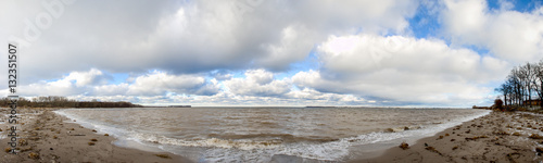 Panorama Baltic sea beach after a storm with blue cloudy sky