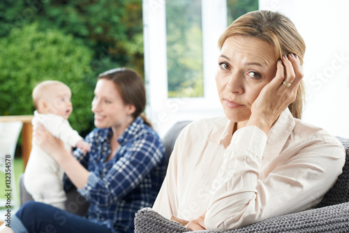 Sad Mature Woman Jealous Of Mother With Young Baby photo