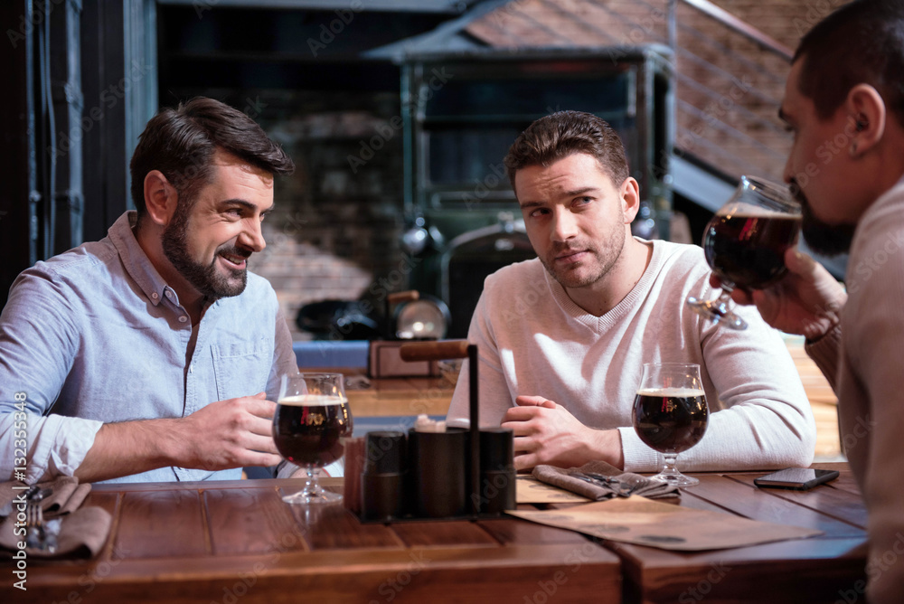 Cheerful male friends sitting at the table