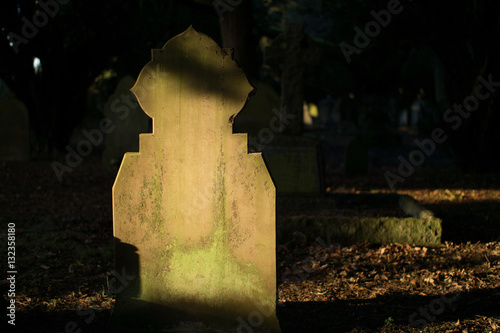 Death, abandoned graveyard with gravestones and overgrown tombstones. Death and burial. Picture of a grave in a graveyard. 