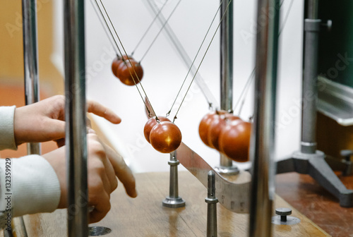 Experiment with balls in laboratory. Research concept. Conservation of energy. Simple Pendulums. When pendulum moving towards the mean position the potential energy is converted to kinetic energy. photo
