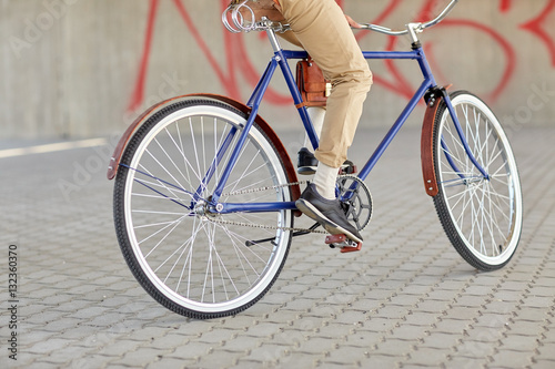 close up of hipster man riding fixed gear bike