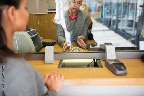Print op canvas clerk with cash money and customer at bank office