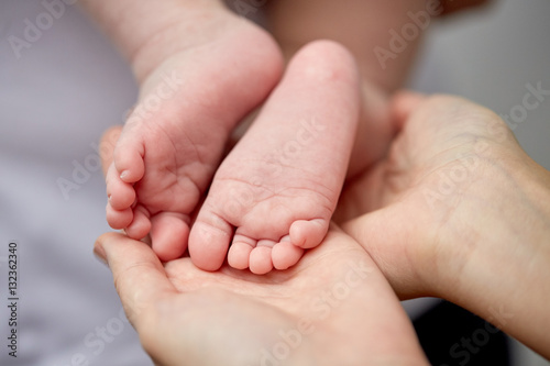 close up of newborn baby feet in mother hands