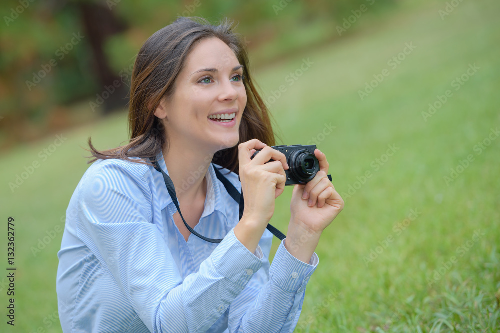 Woman in park taking photograph Woman in park taking photograph