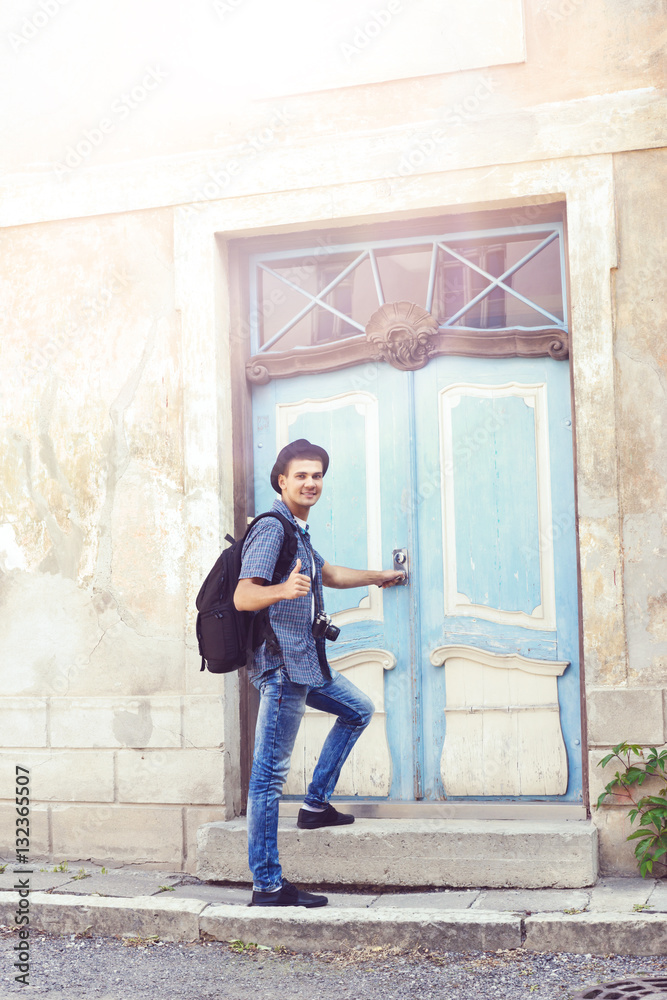 Young hipster standing near an old door Young hipster standing near an old door