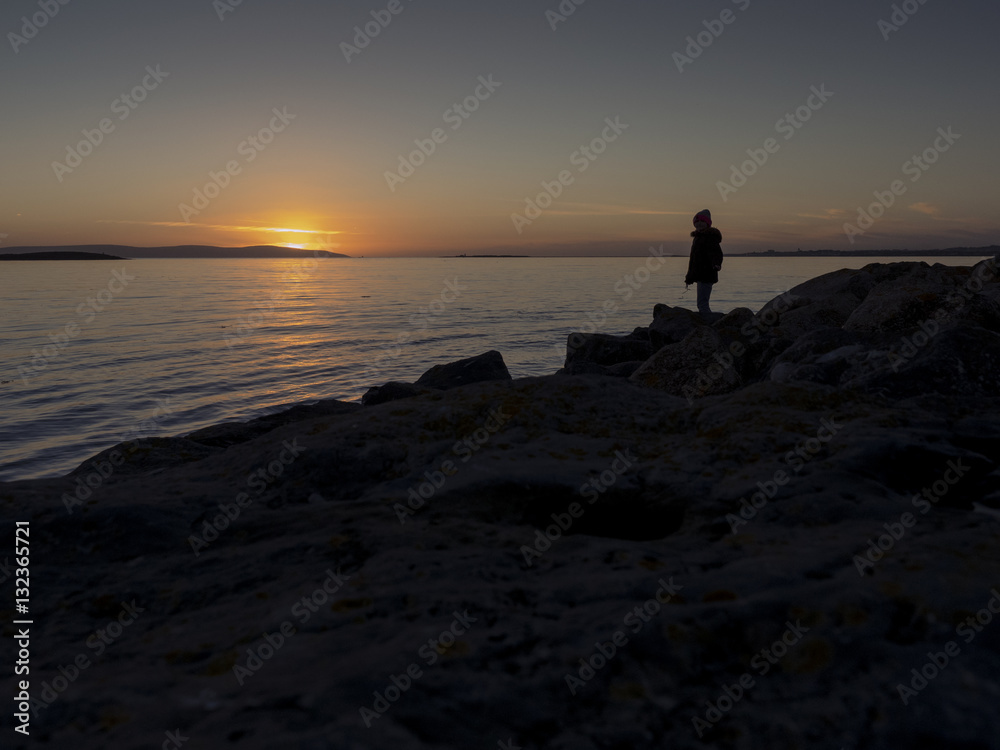 Teenager silhouette at sunset on a sea-shore. Teenager silhouette at sunset on a sea-shore.