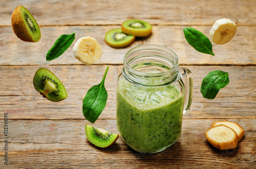 Kiwi banana spinach smoothie with flying pieces