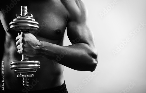 Man training with dumbbell. Black and white photo