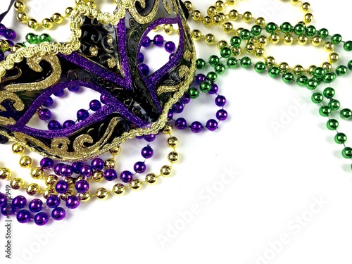 Maris gras mask and beads on a white background with copy space