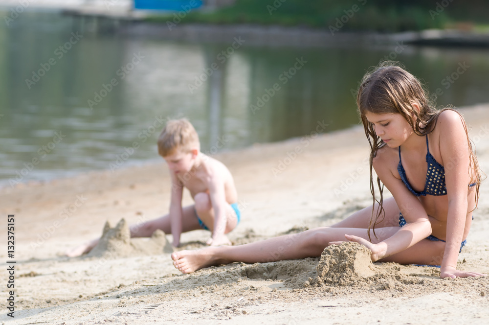 Two children plays with sand