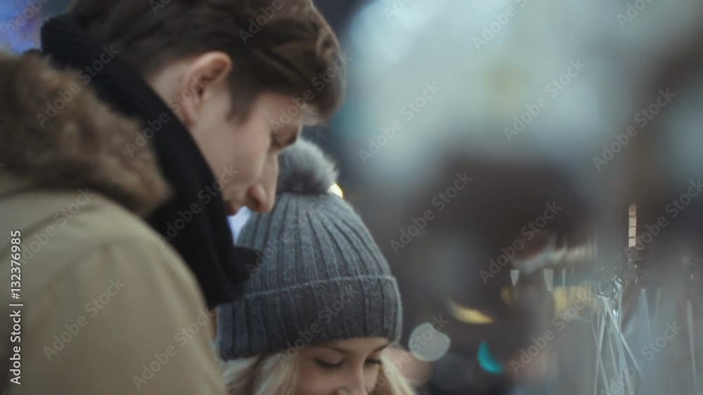 Young happy couple in love enjoying time over evening lights in a city. Beautiful bokeh lights background. Young happy couple in love enjoying time over evening lights in a city. Beautiful bokeh lights background.