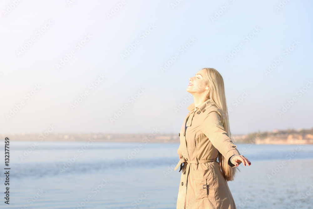 Beautiful young woman near river on sunny autumn day Beautiful young woman near river on sunny autumn day