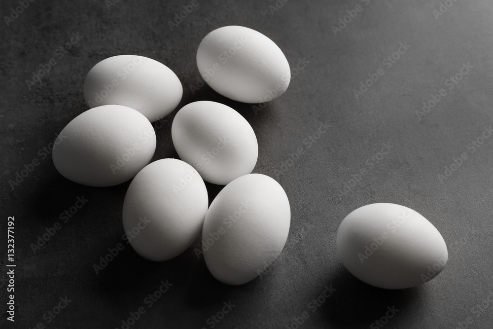 Raw eggs on color background