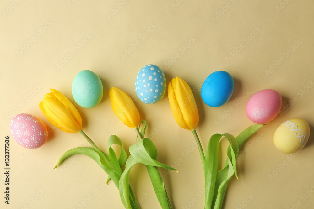Colourful Easter eggs and flowers on beige background Colourful Easter eggs and flowers on beige background