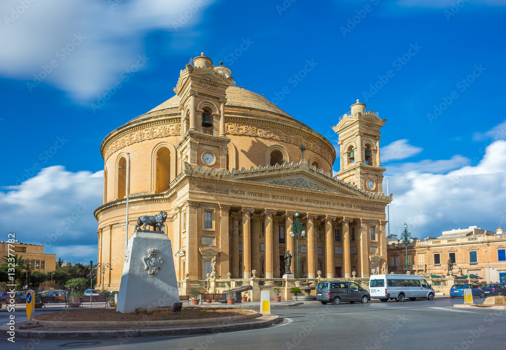 Mosta, Malta - The Church of the Assumption of Our Lady, commonly known as the Rotunda of Mosta or Mosta Dome at daylight with moving clouds and blue sky