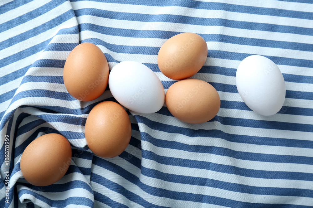Raw eggs on blue fabric background Raw eggs on blue fabric background