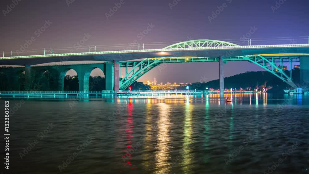 Time Lapse of illuminated railway bridge at night. Light reflections in the water Time Lapse of illuminated railway bridge at night. Light reflections in the water