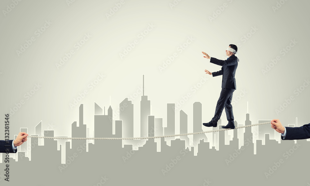 Business concept of risk support and assistance with man balancing on rope Business concept of risk support and assistance with man balancing on rope