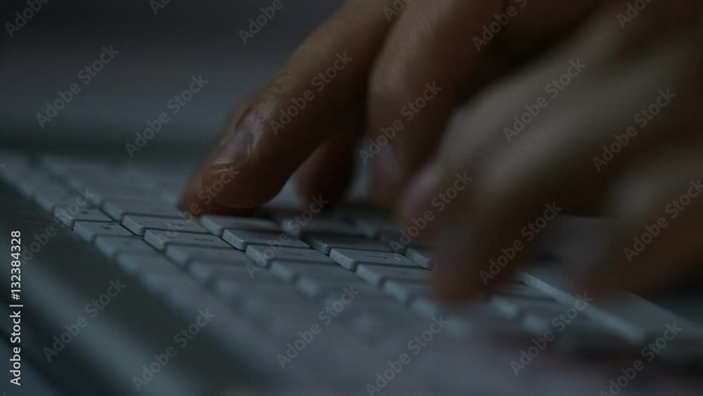 4K Hands typing on a keyboard at night