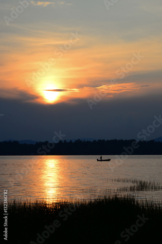 Man in boat fishing at dusk