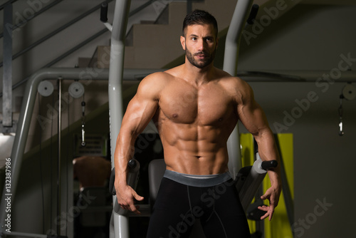 Muscular Man Flexing Muscles In Gym