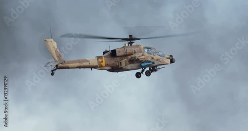AH-64 Apache attack helicopter firing 30mm canon during combat maneuvers photo