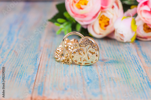 gold bracelet with heart on color wood photo